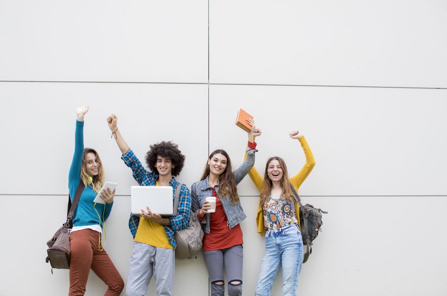 4 jeunes étudiants levant les bras en l'air